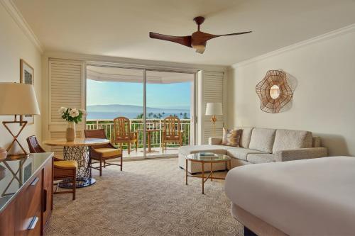 a hotel room with a bed and a living room at Grand Wailea Resort Hotel & Spa, A Waldorf Astoria Resort in Wailea