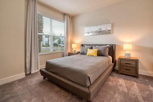 1 dormitorio con 1 cama con 2 lámparas y una ventana en Spacious New Modern Retreat, en Orlando