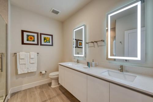 a bathroom with a sink and a toilet and a mirror at Spacious New Modern Retreat in Orlando