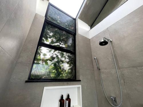 Un baño con ducha con ventana y lavabo. en Cabana na montanha com Ofurô ao ar livre, churrasqueira, trilha com cascata e Starlink, en Cambuí