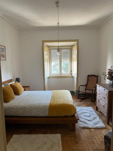 a bedroom with a bed and a dresser and a window at casa da vila in Mora