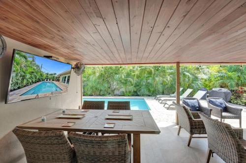 a patio with a table and chairs and a swimming pool at Windward Escape in Fort Lauderdale