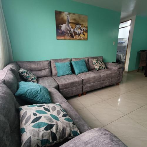 a living room with a brown couch and blue walls at Pablin in Trujillo