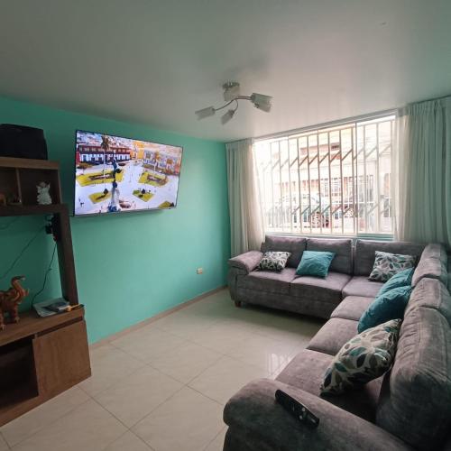 a living room with a couch and a flat screen tv at Pablin in Trujillo