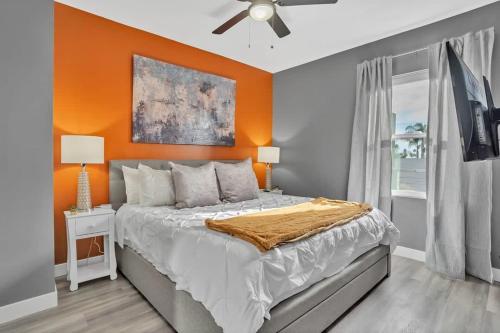 a bedroom with a bed with an orange wall at Professionals-Restaurants-FastWiFi-A C-Desk- Pets in San Diego