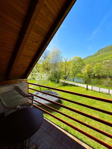 a porch with a bench and a view of a river at River View Tiny House with Garden in Šipovo