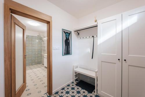 baño con puerta blanca y suelo de baldosa en Apartmán U Zámku - Apartment by the Castle, en Strakonice