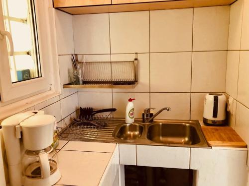 una piccola cucina con lavandino e finestra di Joy City Stay Unirii19 a Timişoara