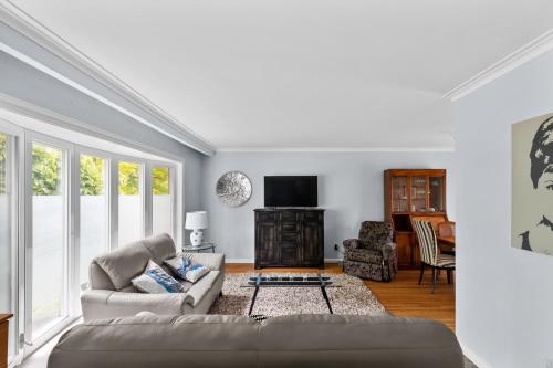 ein Wohnzimmer mit einem Sofa und einem TV in der Unterkunft 3 BR Oakville House Picturesque Neighbourhood in Oakville