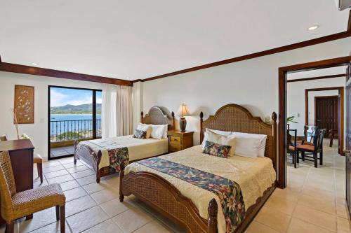 a hotel room with two beds and a balcony at Remodeled Top-Floor Flamingo Condo with Outstanding Ocean Views in Playa Flamingo