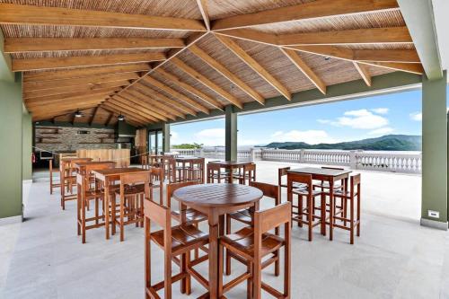 a group of tables and chairs on a patio at Luxury Condo with Panoramic Ocean Views, Sparkling Infinity Pool, and Modern Open-Concept Design in Playa Flamingo