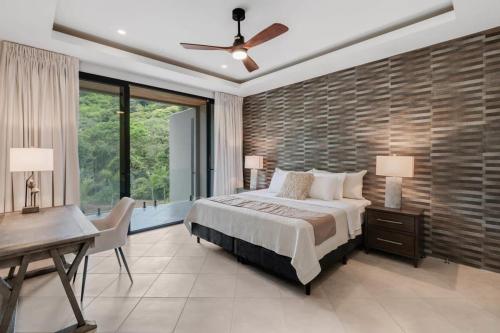 um quarto com uma cama grande, uma secretária e uma janela em Casa Vi em Brasilito