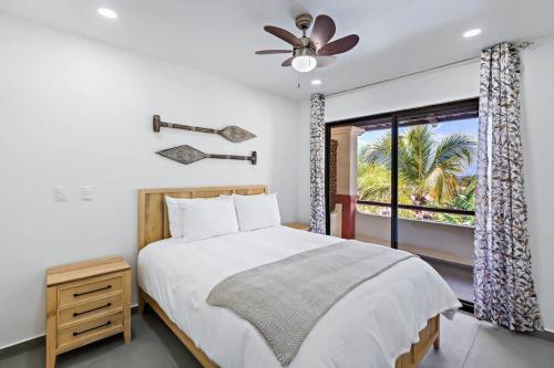 um quarto com uma cama, uma ventoinha de tecto e uma janela em Coco Sunset Hills #20 Coco 2-BD Beauty with Pool Walk to Beach em Coco