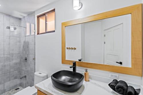 uma casa de banho com um lavatório preto e um espelho em Coco Sunset Hills #20 Coco 2-BD Beauty with Pool Walk to Beach em Coco