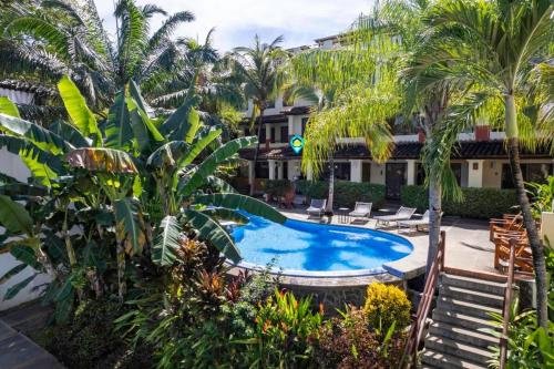 a pool in the middle of a resort with palm trees at Modern Split-Level 2-Bedroom Condo with Pools, Terrace & Easy Beach Access in Coco