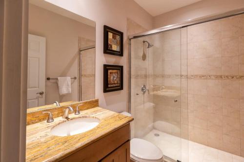 a bathroom with a sink and a shower and a toilet at 3-Bedroom 2-Bath Condo Overlooking Pool in Coco
