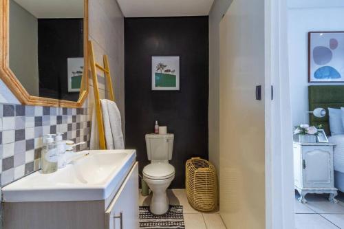 uma casa de banho com um WC branco e um lavatório. em 1 Bedroom Apartment in Houghton with Uninterrupted WiFi em Joanesburgo