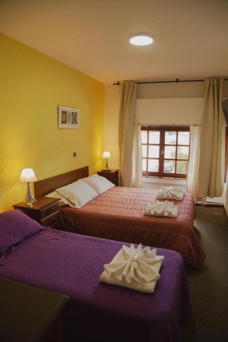 a hotel room with two beds and a window at HOSTERIA AKINO in Esquel