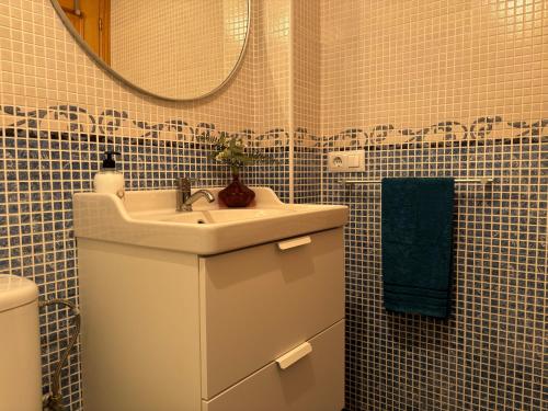 een badkamer met een wastafel en een spiegel bij Desconectaengalicia La Lanzada, 200m playa in A Lanzada