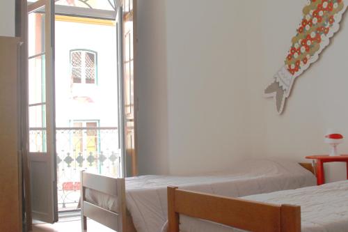 a bedroom with two beds and an open window at Hostel 2300 Thomar in Tomar