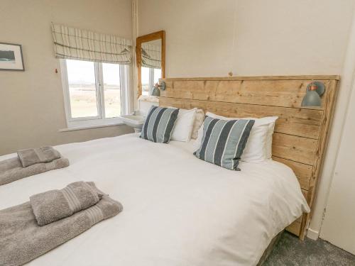 a bedroom with a large white bed with pillows at Wig Carna in Holyhead