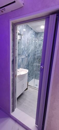 baño púrpura con ducha y espejo en La casetta di Totò, en Nápoles