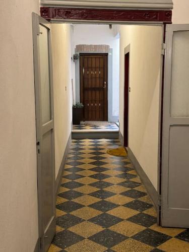 an empty hallway with doors and a checkered floor at Casa Manú centro Bologna in Bologna
