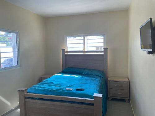 ein kleines Schlafzimmer mit einem Bett mit einer blauen Decke in der Unterkunft House bless in Cancino