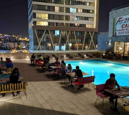 a group of people sitting around a swimming pool at night at Kendi evinizdeymiş gibi konaklama fırsatı.TÜM EV in Istanbul