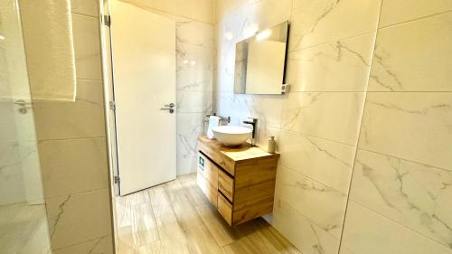 y baño con lavabo, espejo y encimera. en Praia da Rocha, 5-F, Charming Apartment with Air Conditioning - Pátio da Rocha By IG, en Portimão