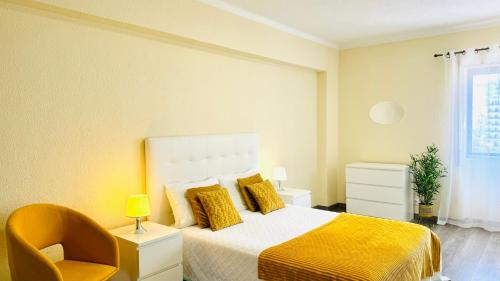 1 dormitorio con 1 cama con manta amarilla y silla amarilla en Praia da Rocha, 5-F, Charming Apartment with Air Conditioning - Pátio da Rocha By IG, en Portimão