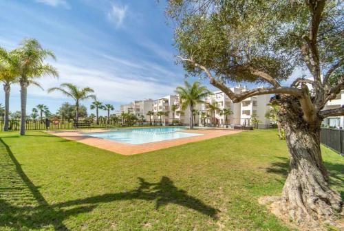 ein Park mit Swimmingpool und Palmen in der Unterkunft Lovely two bedroom Pool & Golf Apartment - SA928LTZ in Roldán