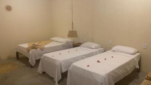 two beds in a room with white sheets at Milagres Retrô- Studio in São Miguel dos Milagres
