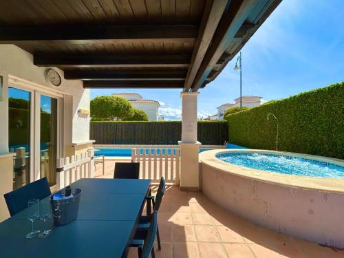 トレ・パチェコにあるVilla with private pool & jacuzzi - CA27LTのテーブルとプールのあるパティオ