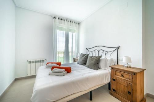 ein Schlafzimmer mit einem großen weißen Bett und einer Holzkommode in der Unterkunft Sunny apartment at La Torre Golf Resort - AO3031LT in Torre-Pacheco