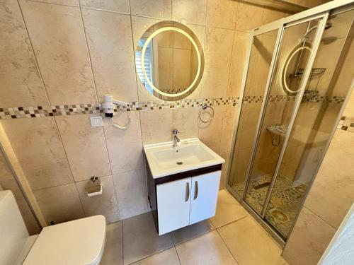 a bathroom with a sink and a shower at Ada Olympos Otel in Bozcaada