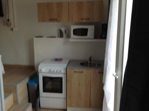 une petite cuisine avec une cuisinière et un micro-ondes dans l'établissement la loggia, à Porto-Vecchio