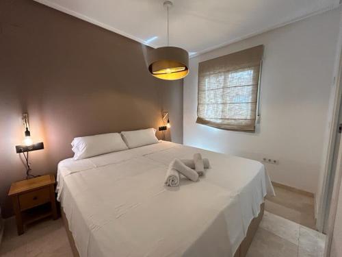 a white bed with a teddy bear sitting on it at Stunning groundfloor apartment - MO2802LT in Los Tomases