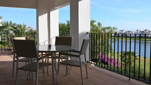 a patio with a table and chairs on a balcony at Apartment with pool & golf views - ER2113LT in Roldán