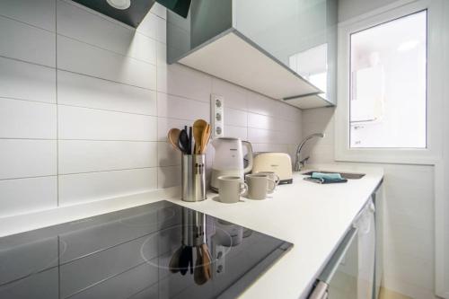 Biała kuchnia z blatem i zlewem w obiekcie Beautiful apartment at La Torre Golf Resort with large terrace - MO4212LT w mieście Torre-Pacheco