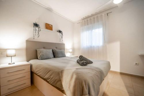 sypialnia z dużym łóżkiem z dwoma butami w obiekcie Beautiful apartment at La Torre Golf Resort with large terrace - MO4212LT w mieście Torre-Pacheco