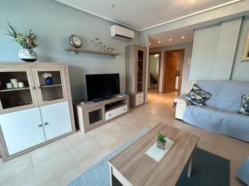 ein Wohnzimmer mit einem blauen Sofa und einem Tisch in der Unterkunft A Lovely Two Bedroom Apartment at La Torre Golf Resort - PA721LT in Roldán