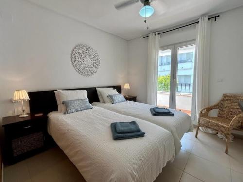 - une chambre avec un grand lit et 2 serviettes dans l'établissement Apartment with pool & golf views - AA2711LT, à Roldán