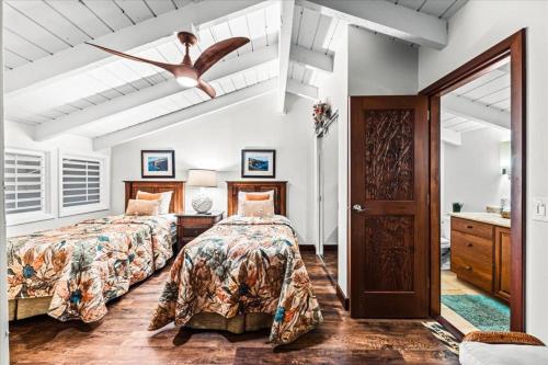 a bedroom with two beds and a ceiling fan at Kuleana Resort 104 in Kahana