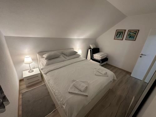 ein Schlafzimmer mit einem großen Bett mit weißer Bettwäsche in der Unterkunft Apartment Rosandić in Smoljanac