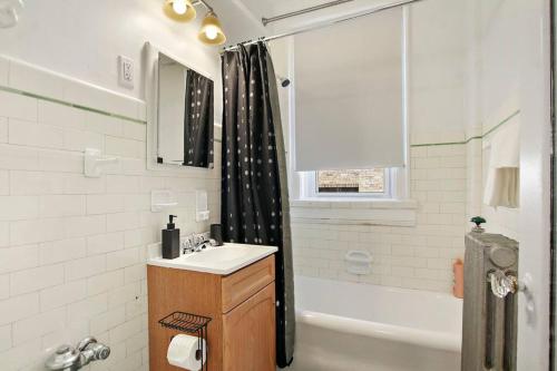 y baño con lavabo, bañera y ducha. en Comfortable Studio Hideaway in Evanston - Elmgate Manor 317, en Evanston
