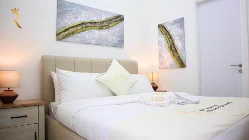 a white bed with two pillows on top of it at Vanilla Grove Calm 2BR Duplex Retreat in Oasis - Tranquil Stay Near Masdar Park & City Centre in Abu Dhabi