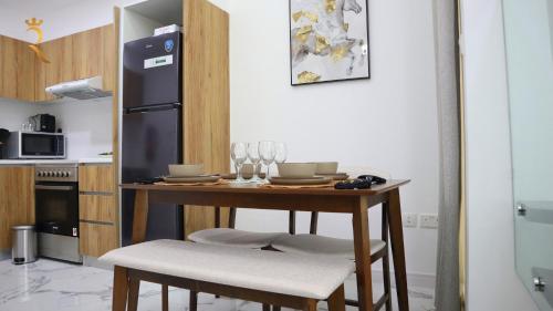 a kitchen with a table with chairs and a refrigerator at 2BR Stylish Duplex - Premium Oasis Retreat in Abu Dhabi