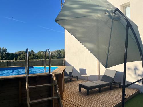 - une terrasse avec un parasol et des chaises à côté de la piscine dans l'établissement Appartement avec piscine au milieu des vignes, aux Arcs-sur-Argens