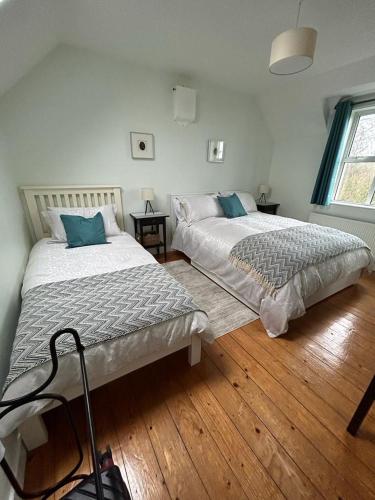 2 camas en un dormitorio con suelo de madera en An Teach Cnoc, en Monaghan